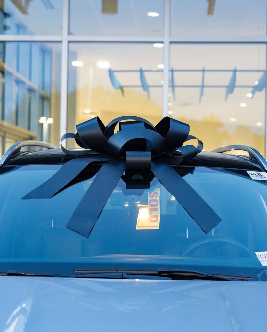 Car marked SOLD with the dealership bow